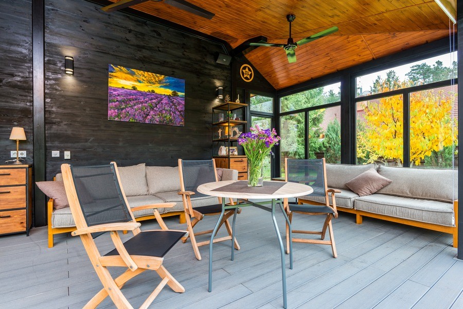 Backyard patio with dramatic foliage, contrasting wood tones and rustic, sophisticated furnishing. 